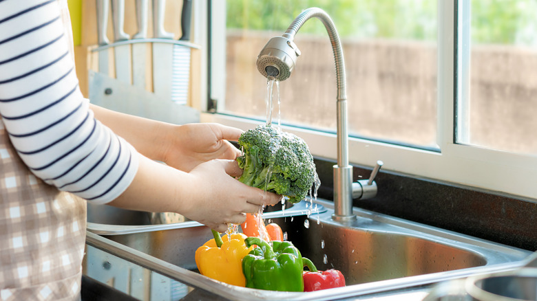 washing vegetables in sink