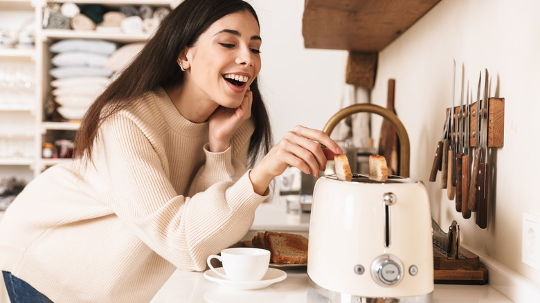 woman toasting bread in kitchen