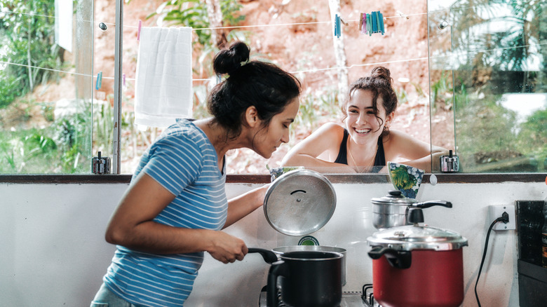 person checking pan on stove