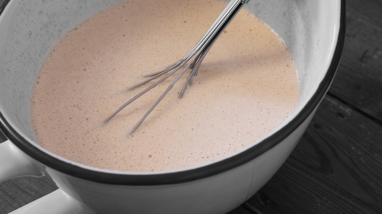 Balloon whisk in batter in a bowl