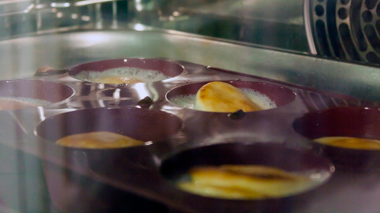 Yorkshire puddings beginning to rise in the oven