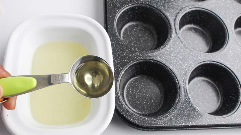 Oil being put in muffin tray 