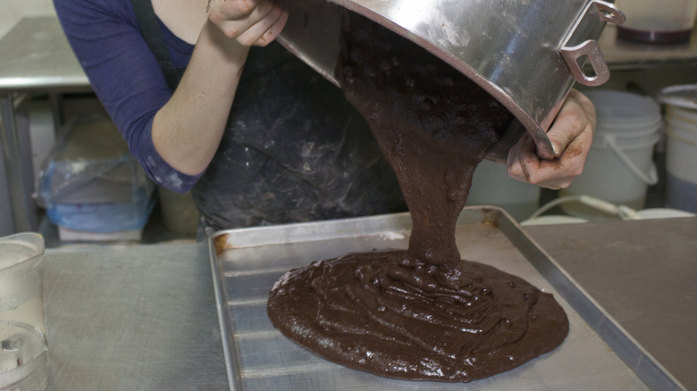 Pouring chocolate cake batter into a pan