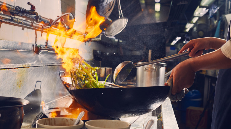 chef cooking with wok