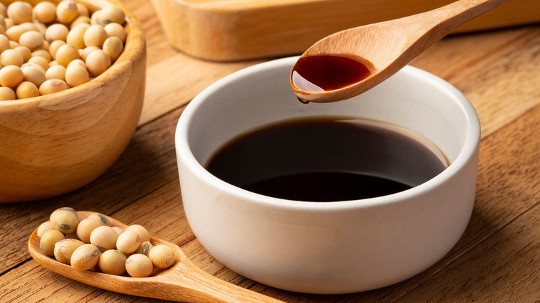 soy sauce in bowl with soybeans in background