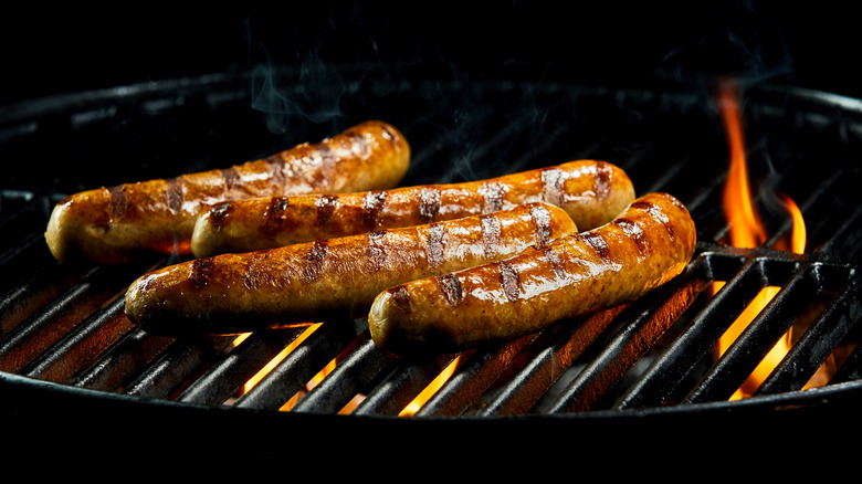 Cooking sausages over charcoal