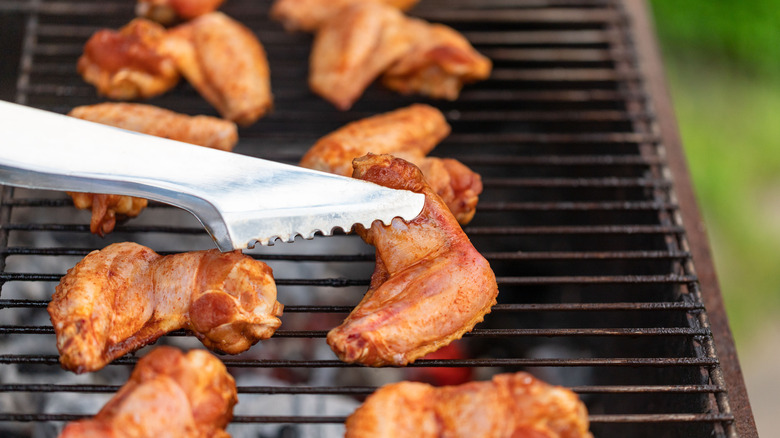 Turning chicken wings with tongs