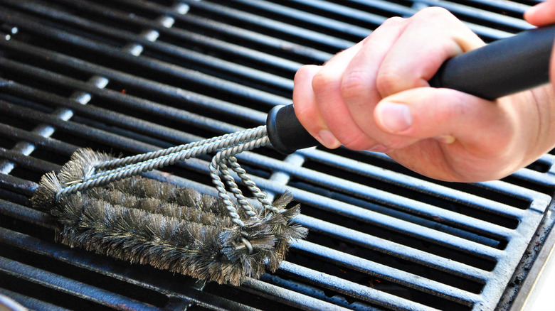 cleaning barbecue with scraper