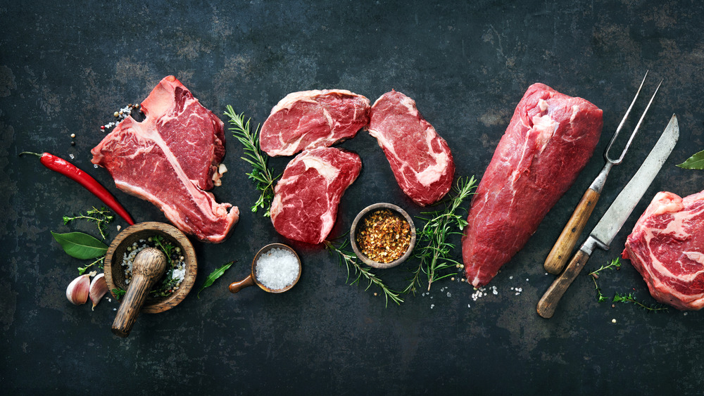 steak cuts with herbs and spices with barbecue tools