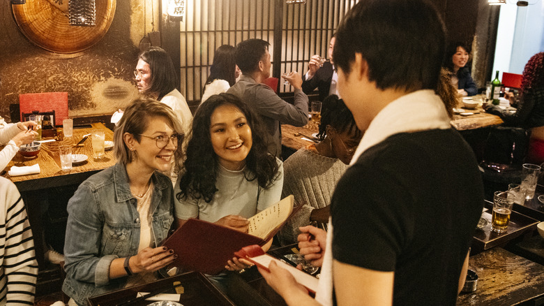 couple talking to waiter in restaurant