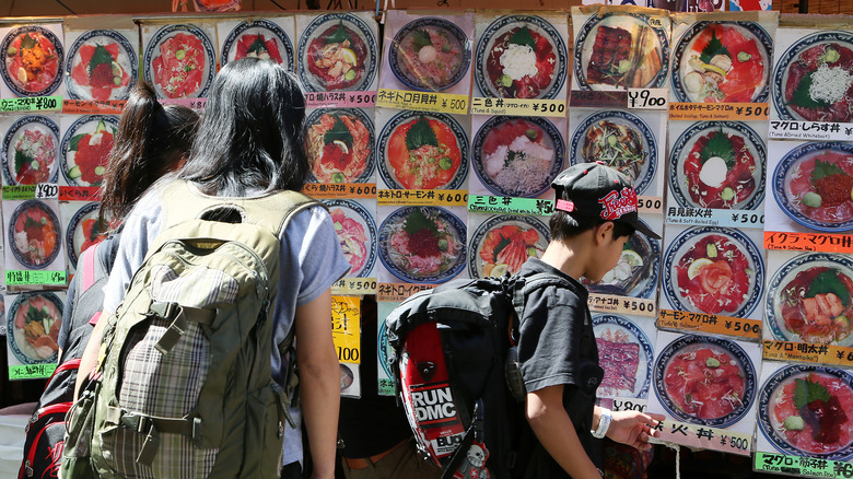 people looking at menu outside Japanese restaurant