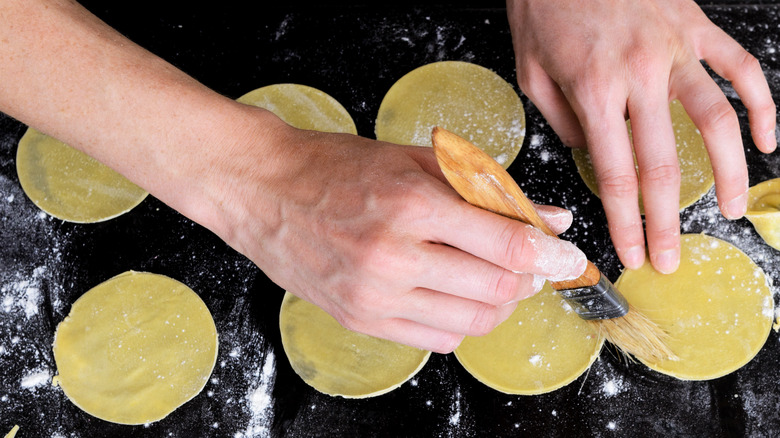 brushing water on dough to seal ravioli