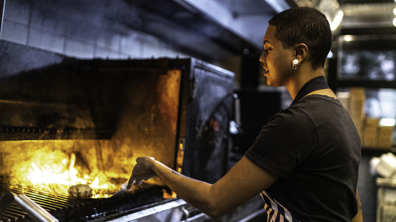 chef grilling a burger with flames 