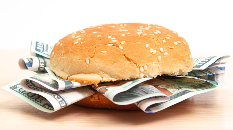 burger bun with 100 dollar bills stuffed inside