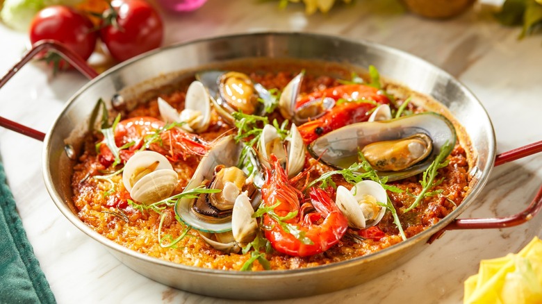 Pan of vibrant seafood paella with shrimp and clams