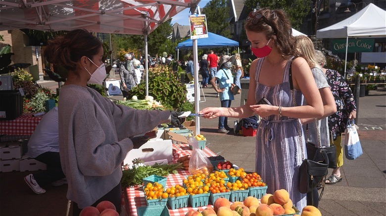 woman paying farmers market 