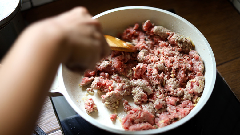 Person breaking up ground beef