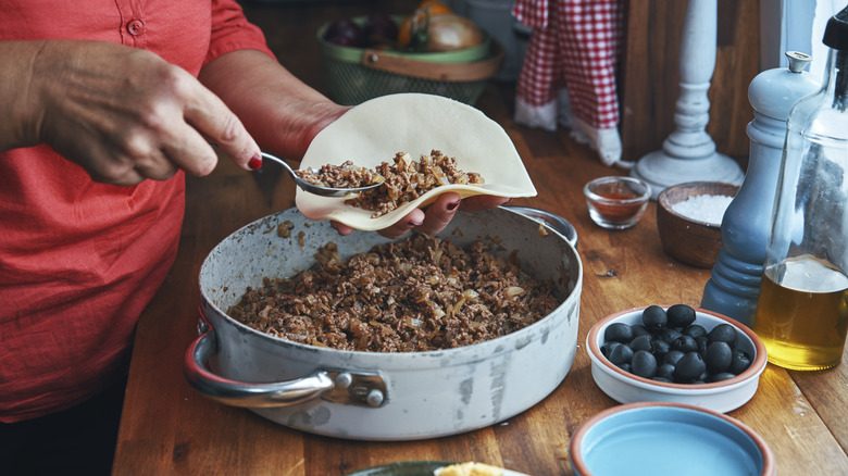Ground beef being placed in tortilla
