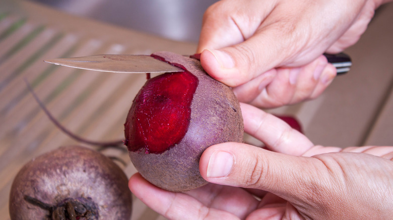 person peeling beets closeup