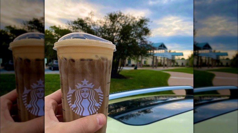 Person holding Starbucks pumpkin iced coffee