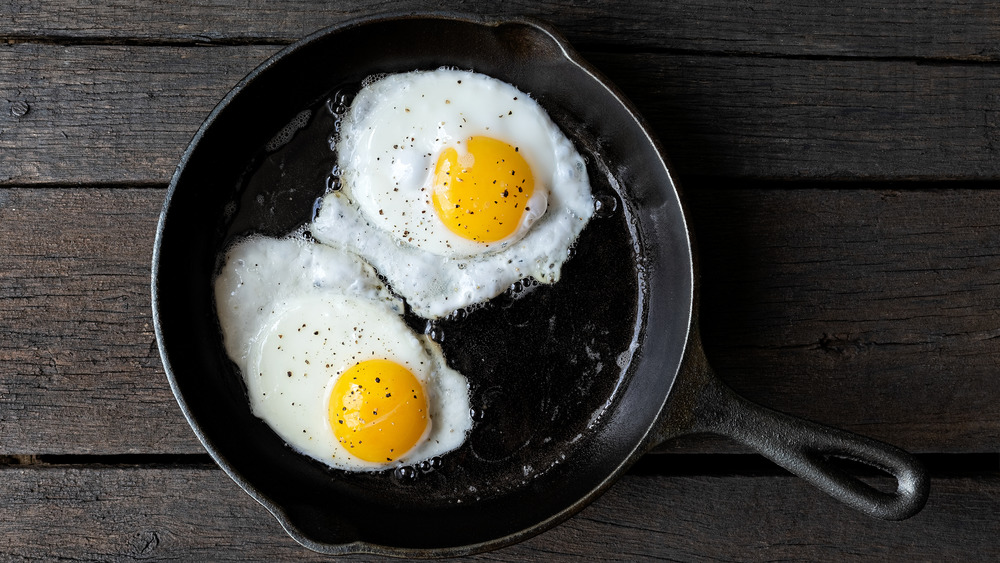 Two fried eggs in a cast iron skillet