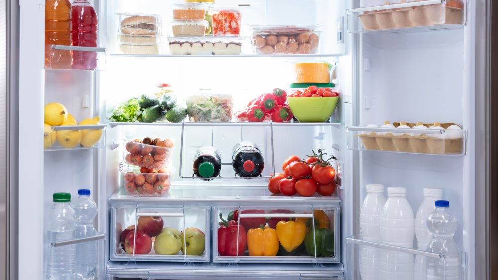 Refrigerator stocked with produce and sweet potatoes