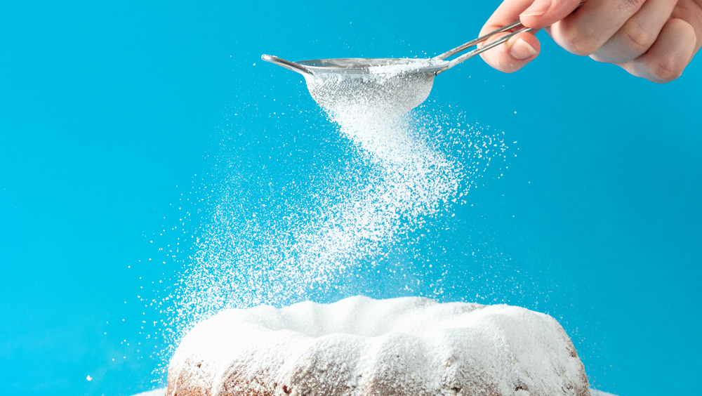 sifting sugar on cake