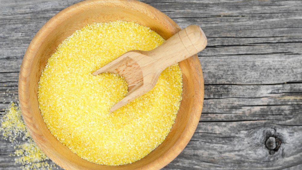 Bowl of cornmeal with wooden table backdrop