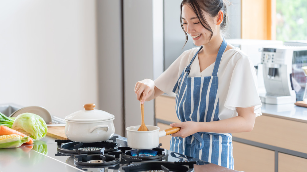 woman stirring pot of food