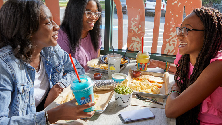 Three teens eating at Moe's