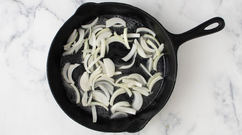 sliced onions cooking in skillet