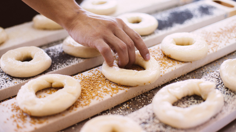 Person making bagels with seasonings