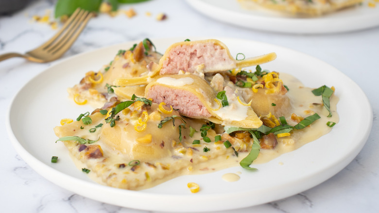 mortadella ravioli with pistachio cream sauce on plate