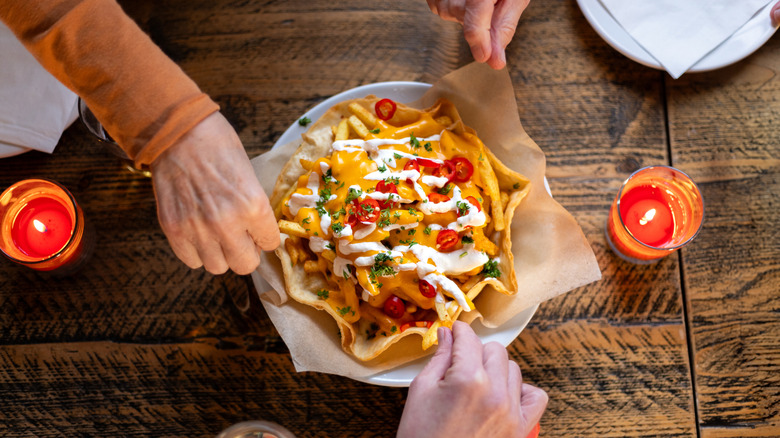 People sharing a tray of loaded fries