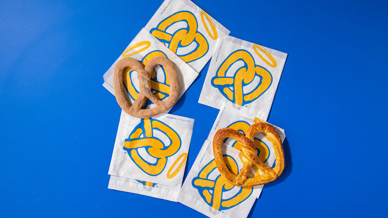 Soft pretzels on blue and yellow bags against blue background