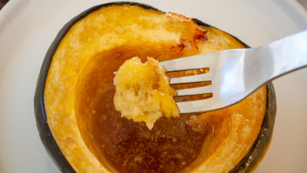 fork digs into acorn squash