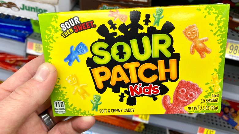 hand holding sour patch kids box