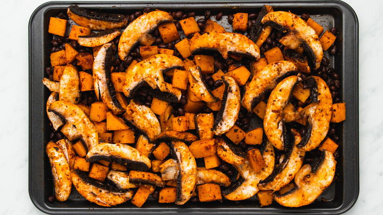 Spice-covered vegetables on baking sheet