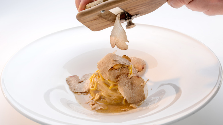 shaving truffle over pasta