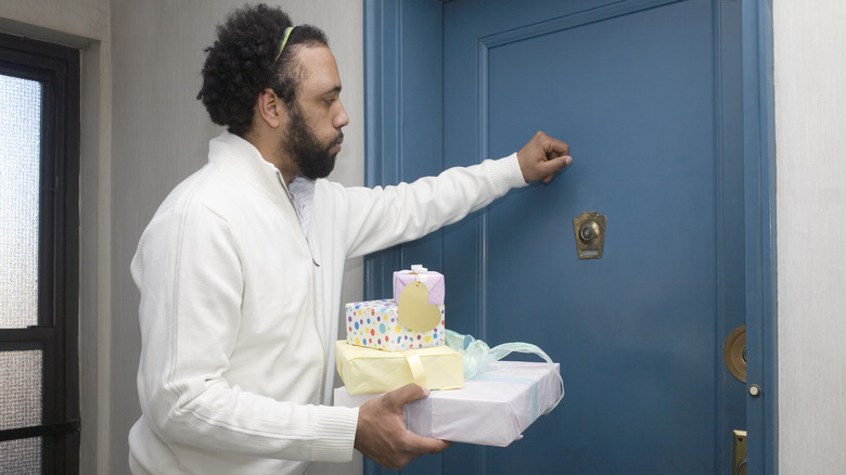 man with presents knocking on door