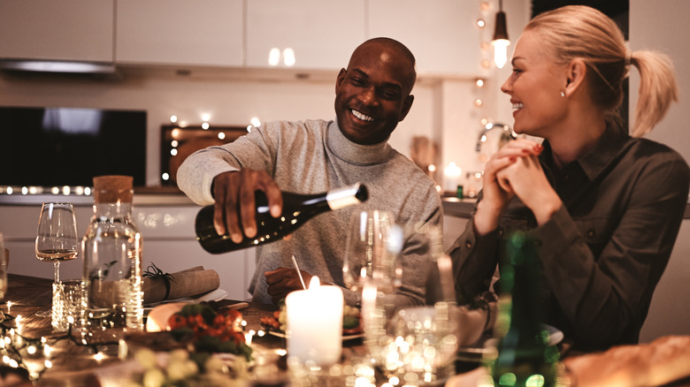 man pouring wine into glass 