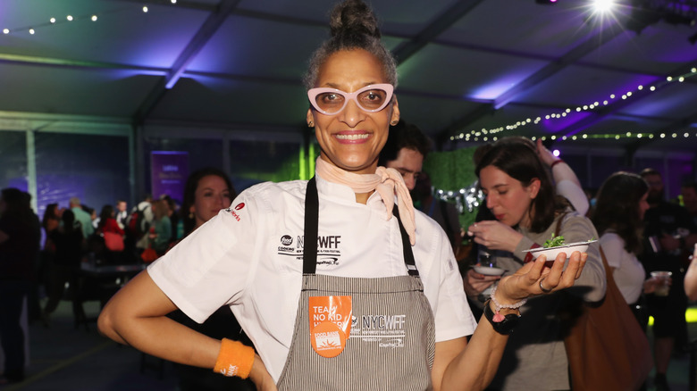 Carla Hall posing in apron