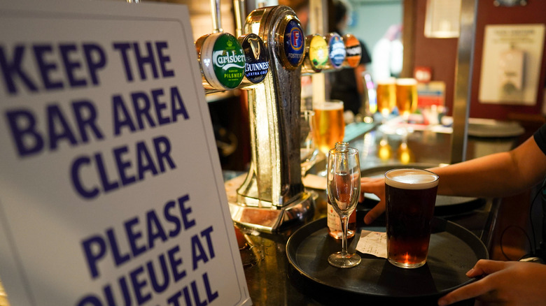 waitress prepares drinks at bar