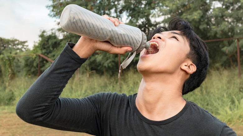 man chugging water