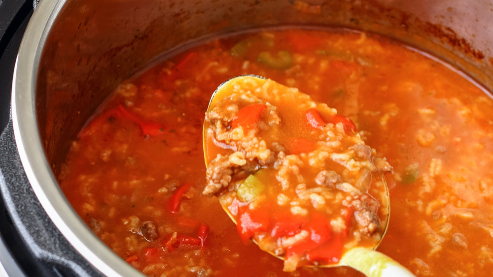 Spoon with meat stew and tomatoes over Instant Pot