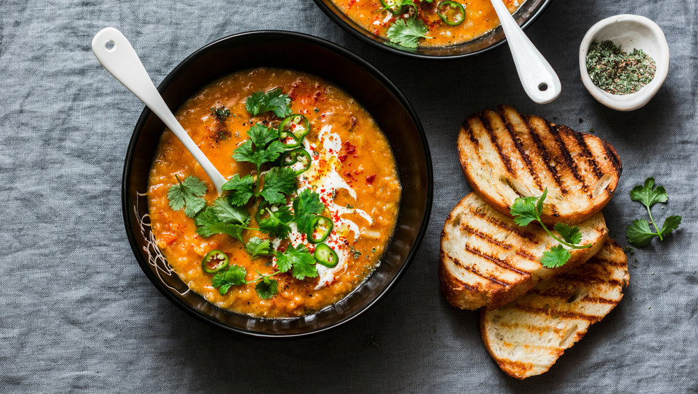 Soup in black bowl next to grilled bread