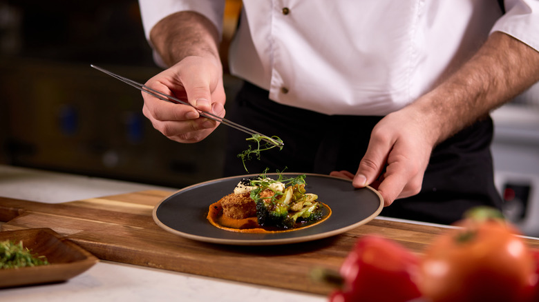 Placing green garnish on a plate