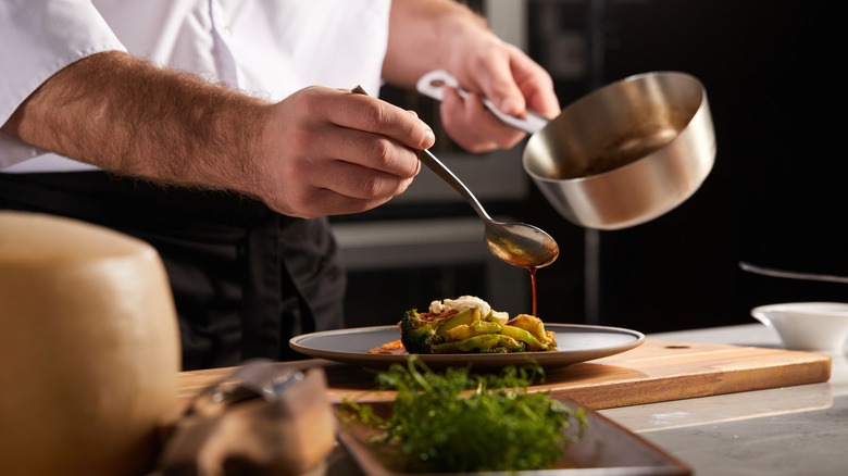 Drizzling sauce on a gray plate