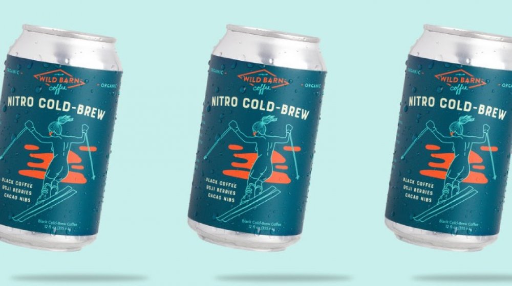 Cans of Wild Barn Coffee against a light blue background