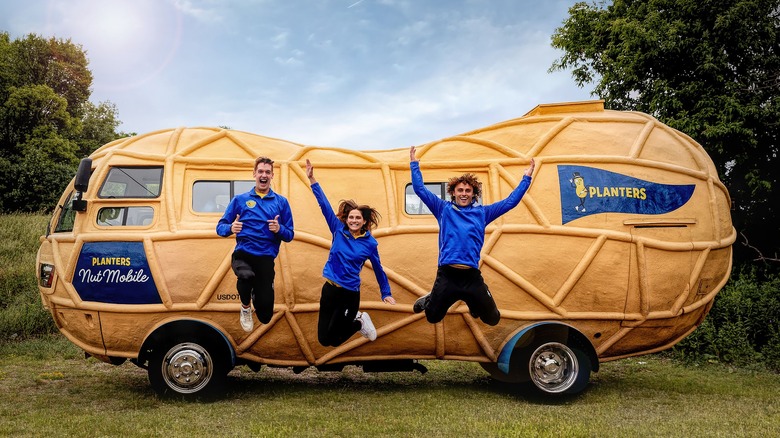 Three people jumping in front of NUTmobile